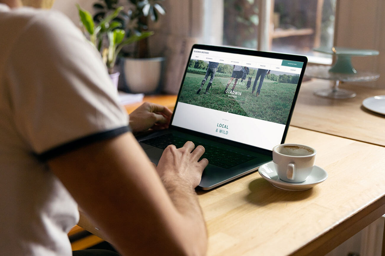 Gladwin Brothers website design shown on a laptop being used by a woman