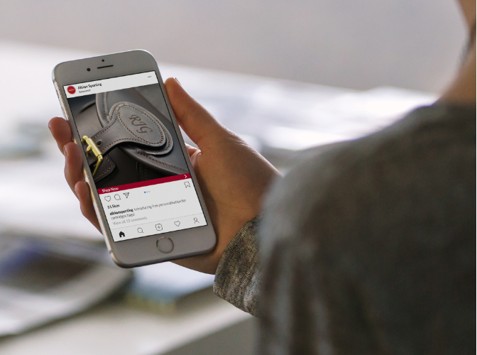 Woman holding phone showcasing Albion Englands mobile website design